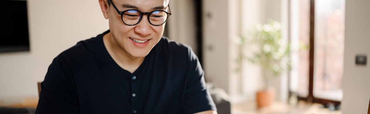 Bespectacled man working on a laptop