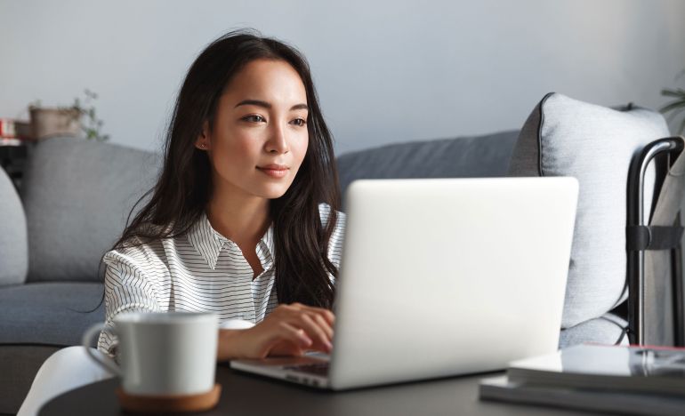 Woman sitting in a living room and looking at her laptop