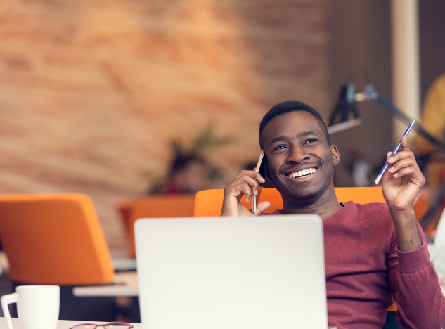Man smiling while having a conversation on his mobile phone