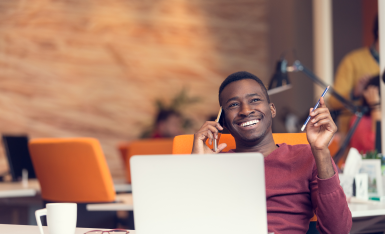 Man smiling while having a conversation on his mobile phone