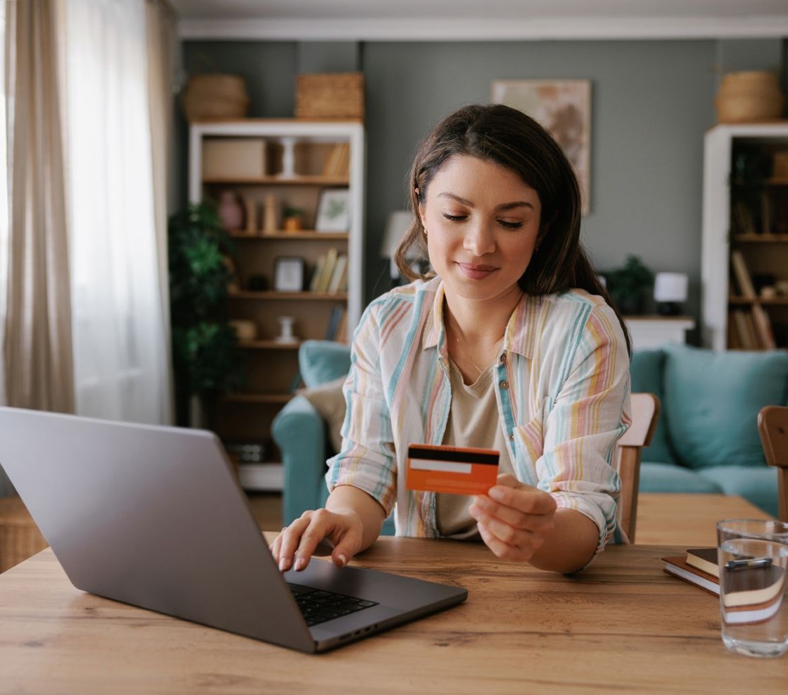 Woman with a credit card typing into a laptop
