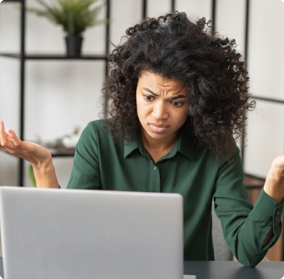 Woman in green shirt looks puzzled at laptop, raising hands in confusion. Background has shelves with a plant. Emotions convey frustration and bewilderment.