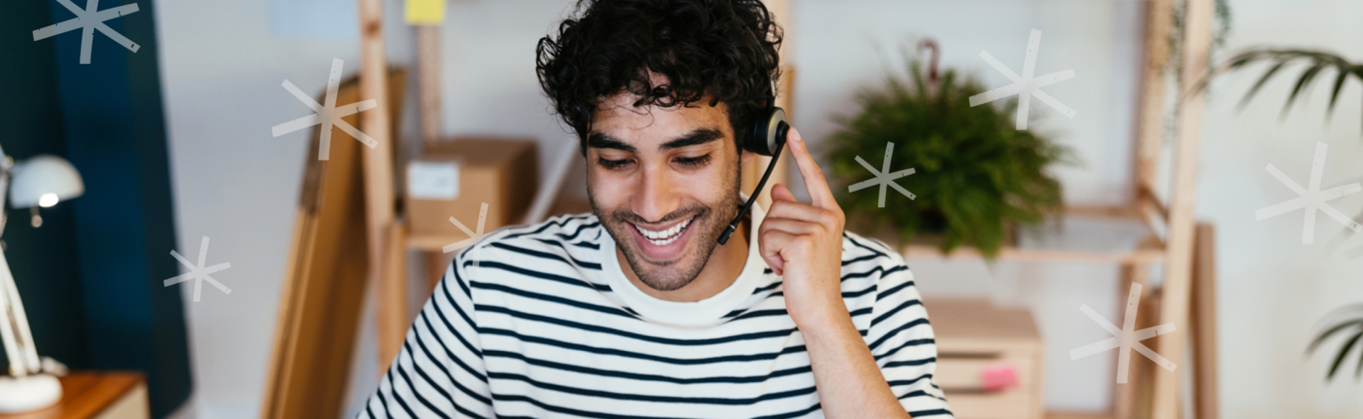 Man in a striped shirt wearing a phone headset and smiling