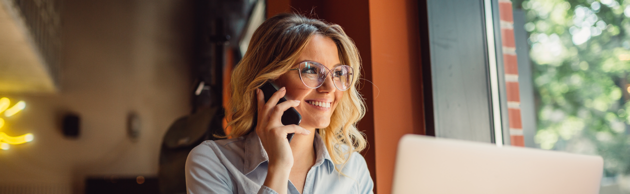 woman having a call while using laptop