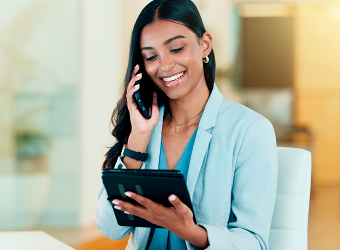 Woman looking at tablet while talking on the phone