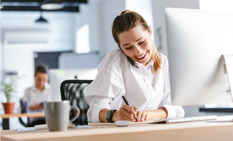 woman writing down notes from a mobile phone call