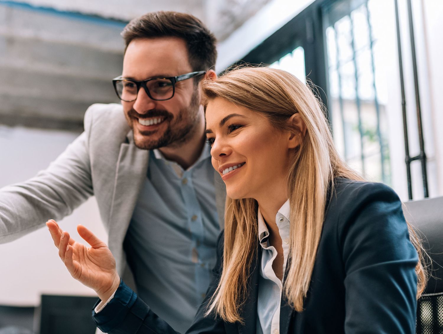 Business man showing business woman something on the computer screen