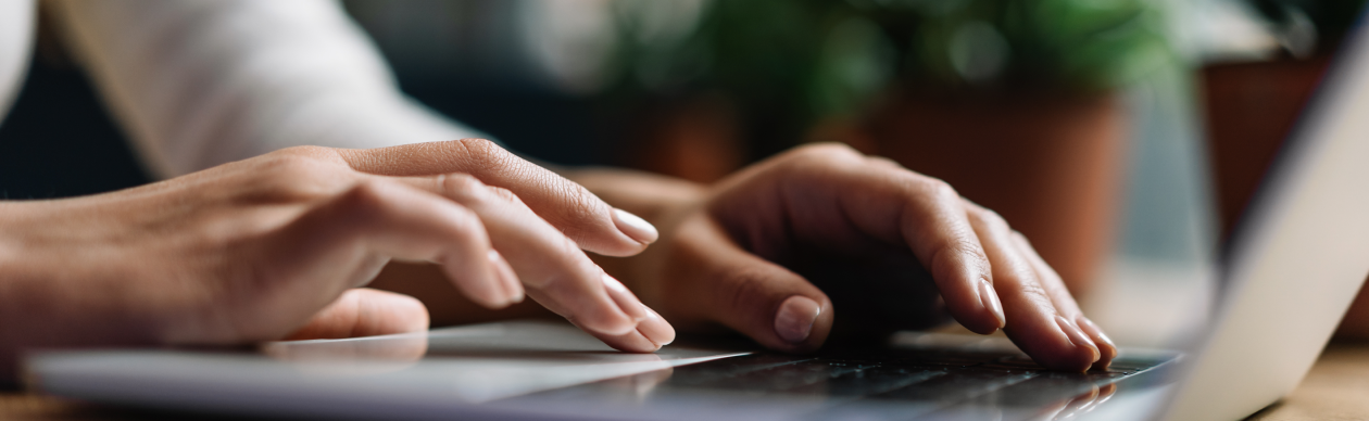 Hands typing on a laptop