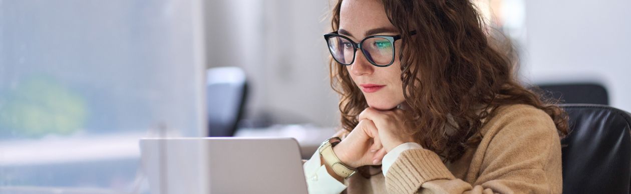 A CX leader looking at her laptop to learn ai terms for customer service