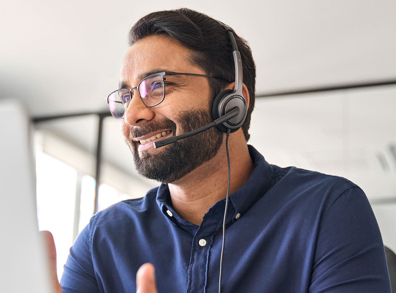 Man with a headset smiling at his computer