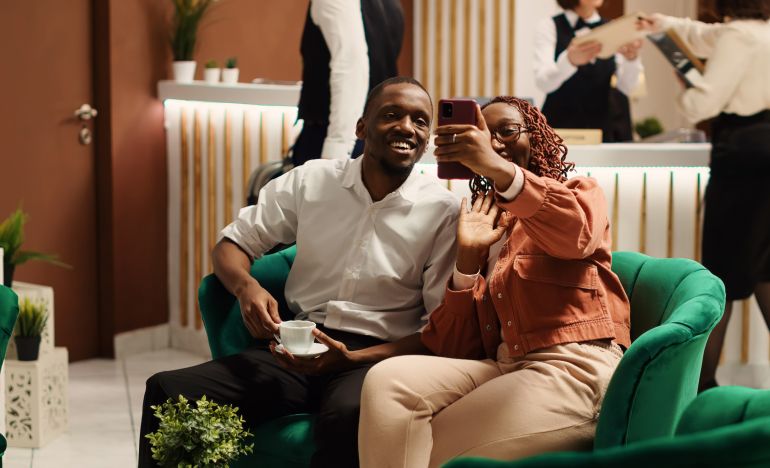 Two people smiling at a smartphone