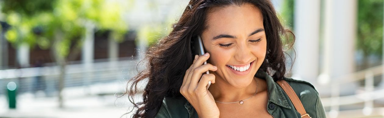 A smiling woman talking on the phone