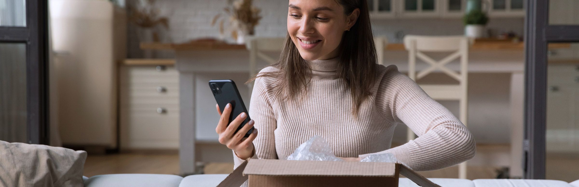 Customer unboxing a package and looking at her phone