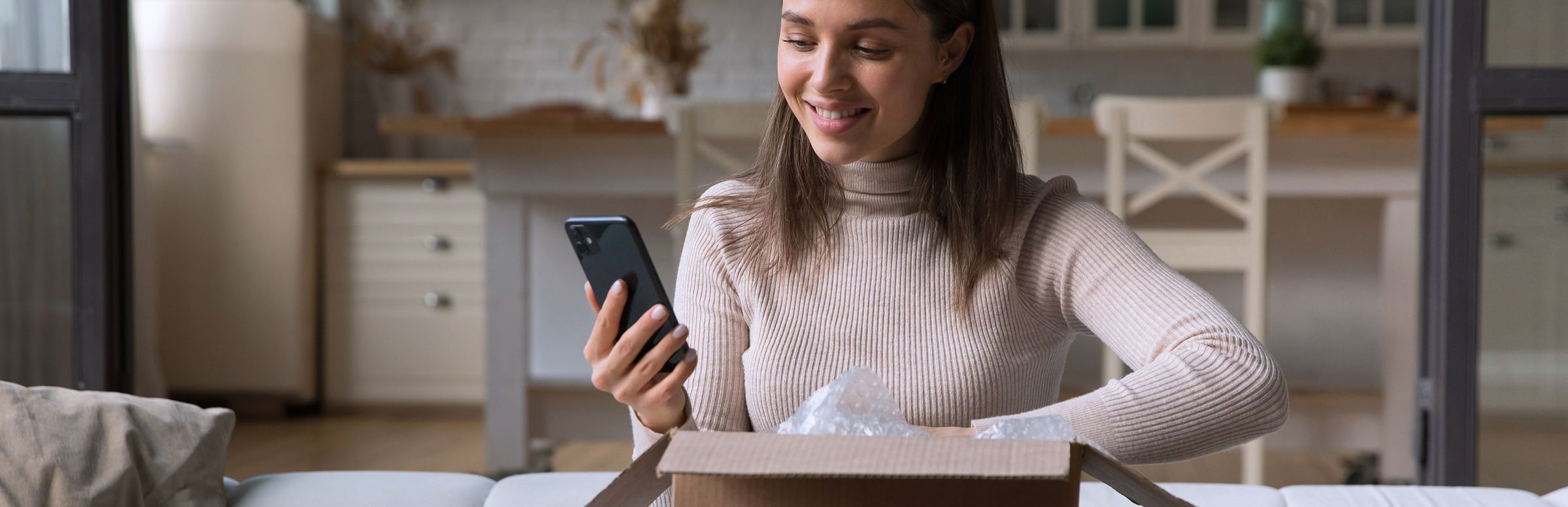 Customer unboxing a package and looking at her phone