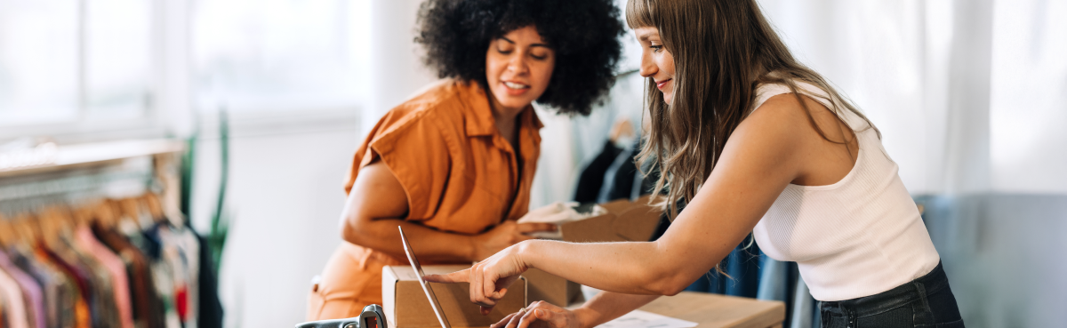 Two women looking at laptop in retail store
