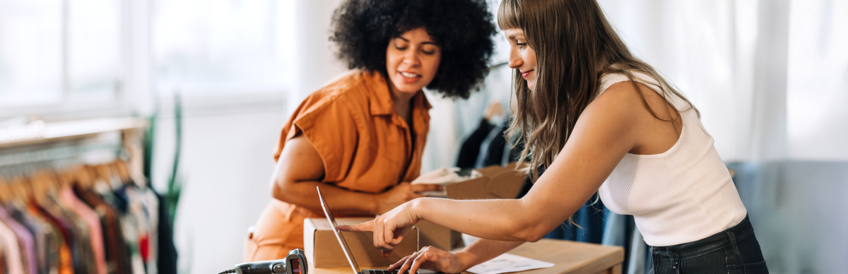 Two women looking at laptop in retail store