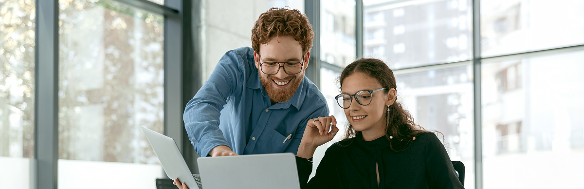Two people collaborating with their laptops