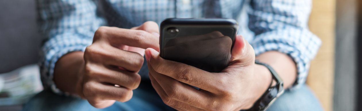 Image of a seated person holding a cellphone