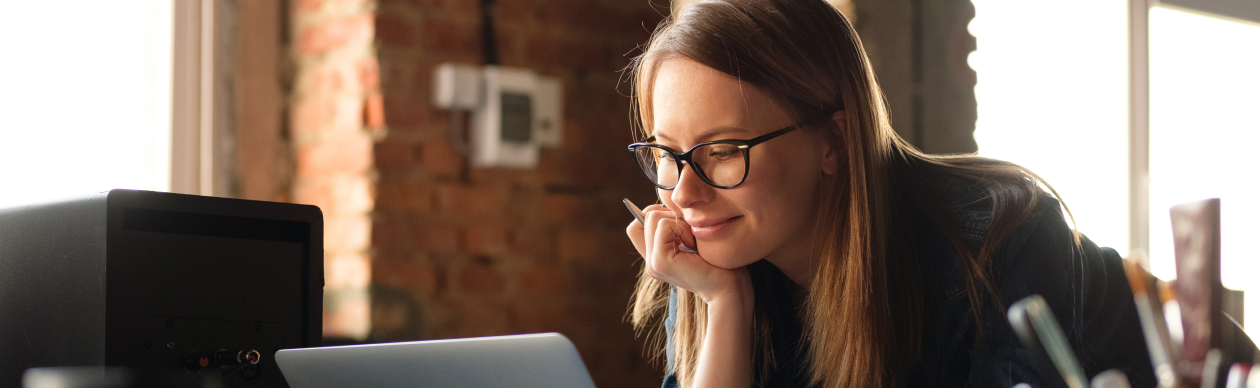 A lady looking at her laptop and strategizing how to best leverage digital service channels