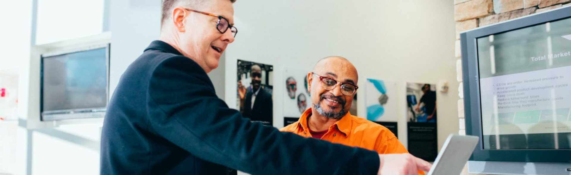 Two men discussing something on a laptop in front of them