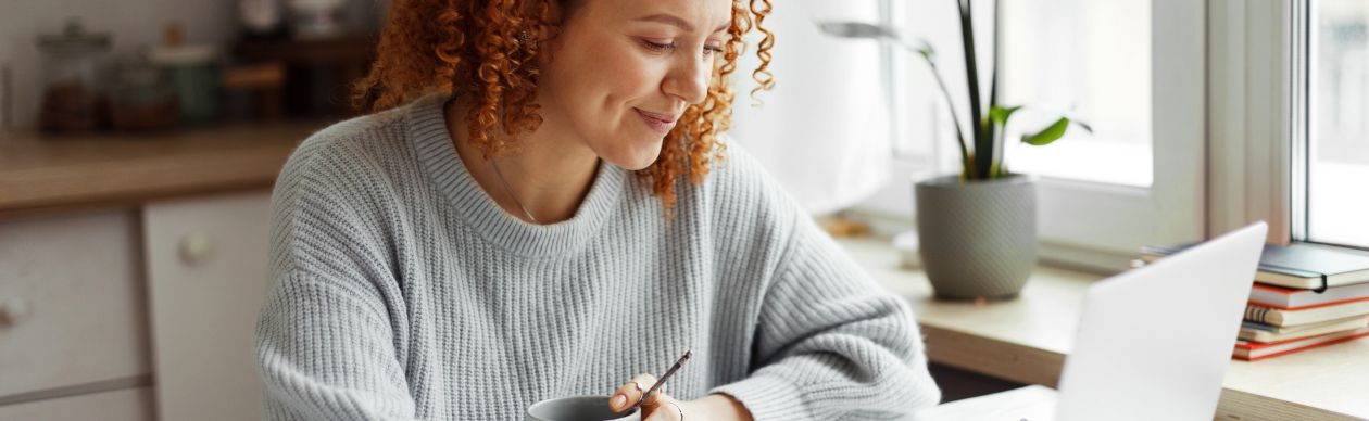 A CX expert on her computer who is happy she was able to reduce the cost of customer service