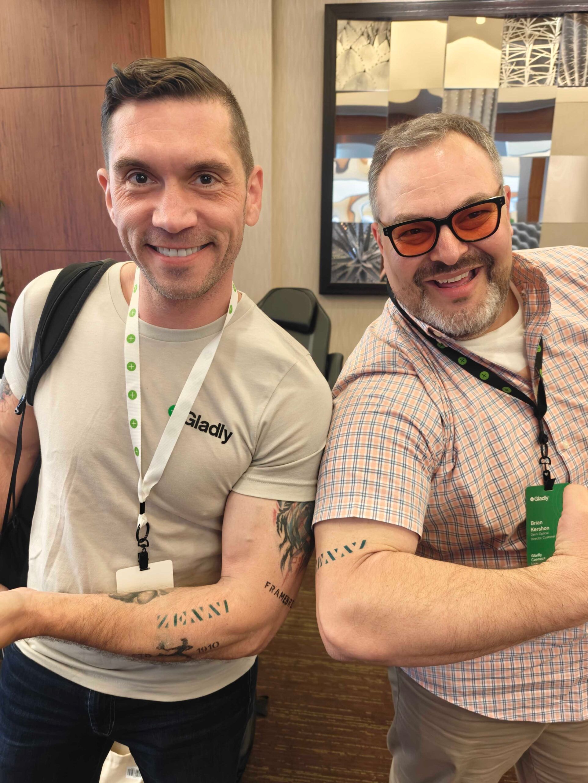 Two people showing off Zenni temporary tattoos on their forearms