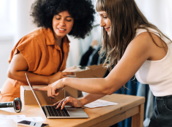 Two women looking at laptop in retail store