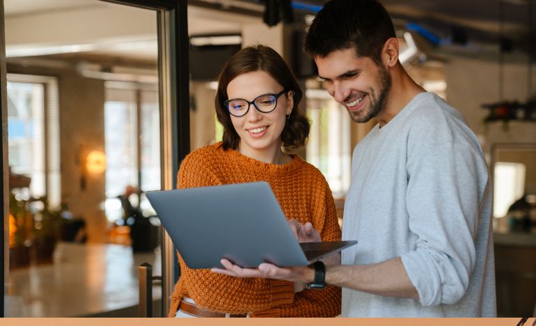 CX practitioners driving change within their org, working together on laptop