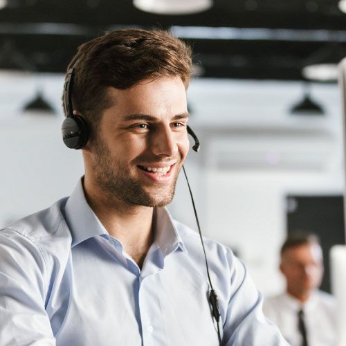 smiling customer service agent with headset on computer