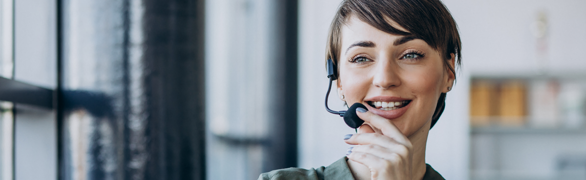 Woman with a phone headset smiling into the mic