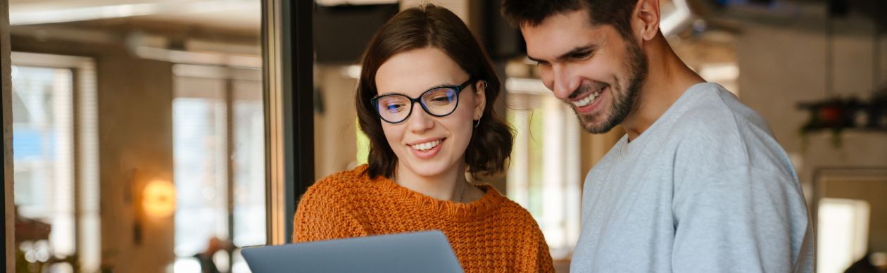 CX practitioners driving change within their org, working together on laptop