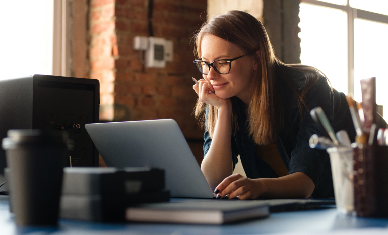 A lady looking at her laptop and strategizing how to best leverage digital service channels
