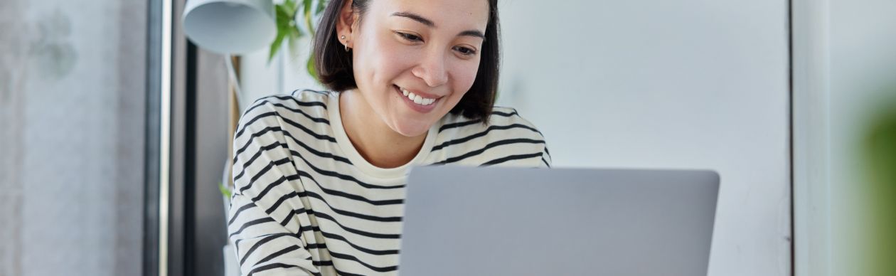 Smiling woman looking at a laptop