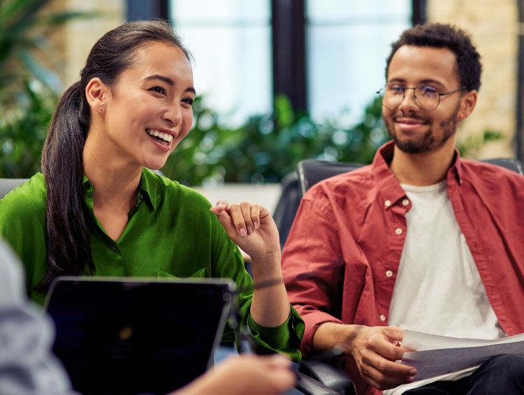 Two coworkers smiling next to each other