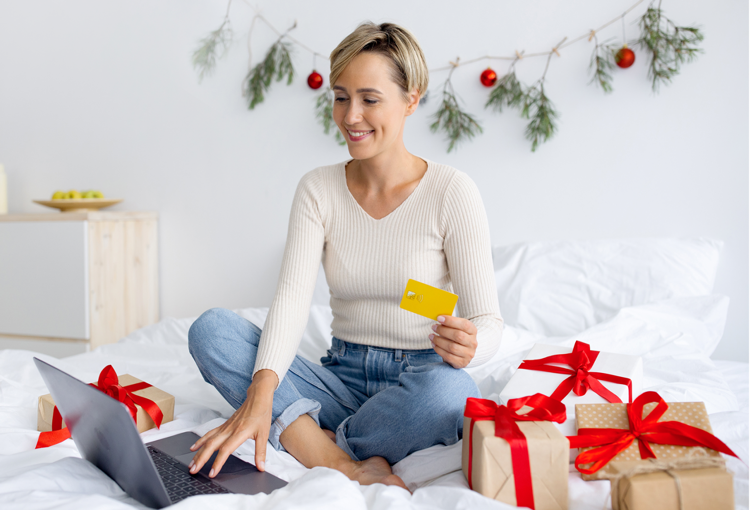 Woman smiling in a living room with Christmas decorations on the wall in the background