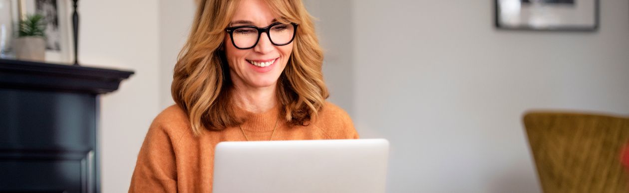 A happy customer at her laptop because your business took measures to improve customer effort scores
