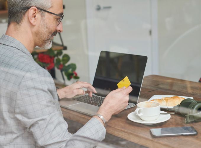 Man paying for something on his computer with a credit card