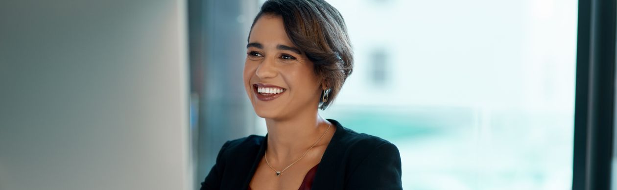 A CX leader working at her computer to improve her leadership skills and by extension, customer service