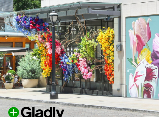 City skyline at sunset featuring tall skyscrapers with lights on, a prominent Ferris wheel in the foreground, and a colorful, vibrant sky.