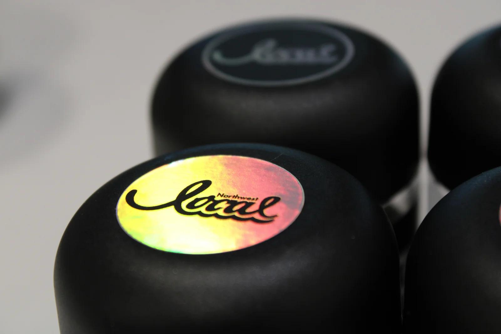 Holographic Northwest Local logo on black jar lids.