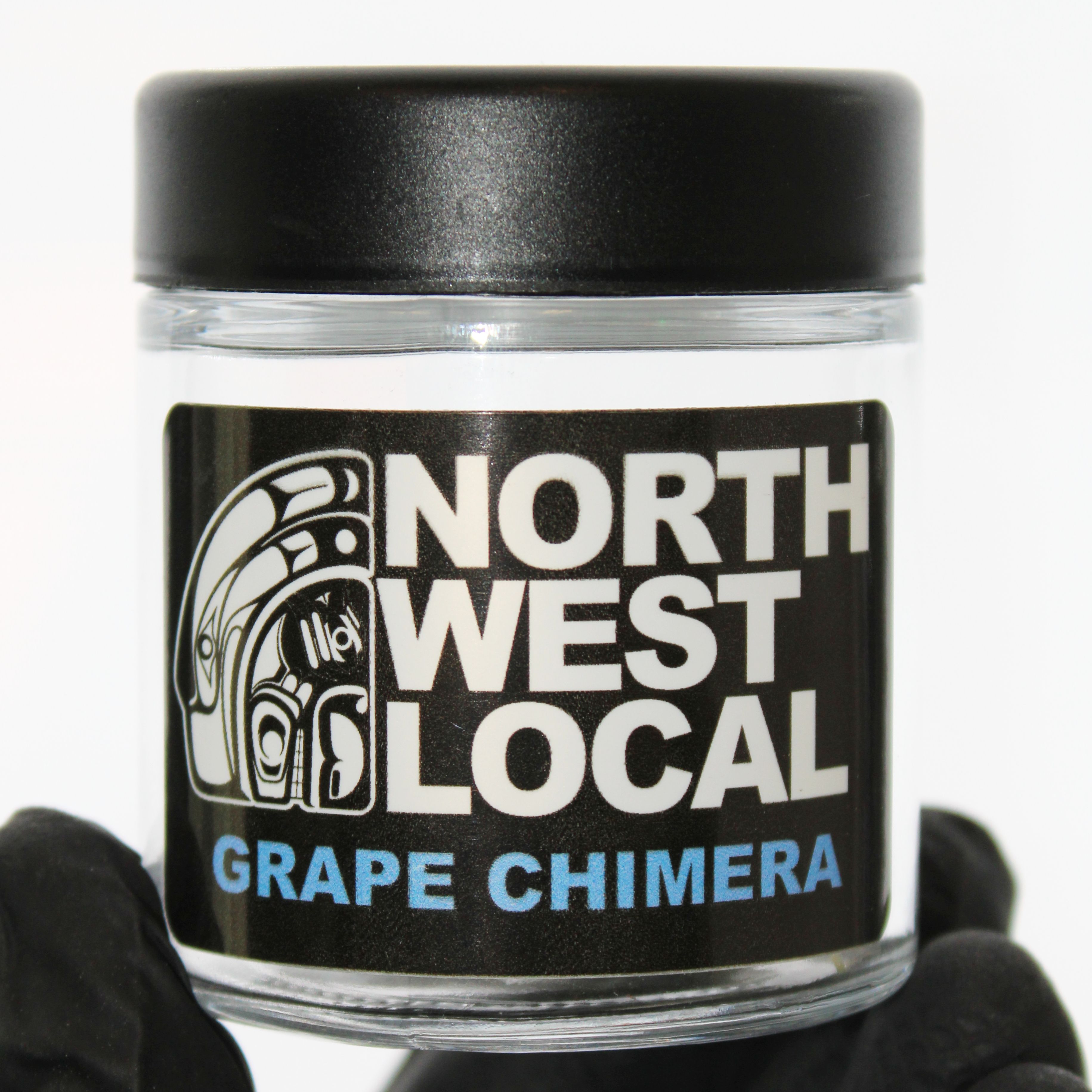 Northwest Local Grape Chimera eighth in a small glass jar with a black lid, the label showing the formline raven logo and the strain name in lavender lettering