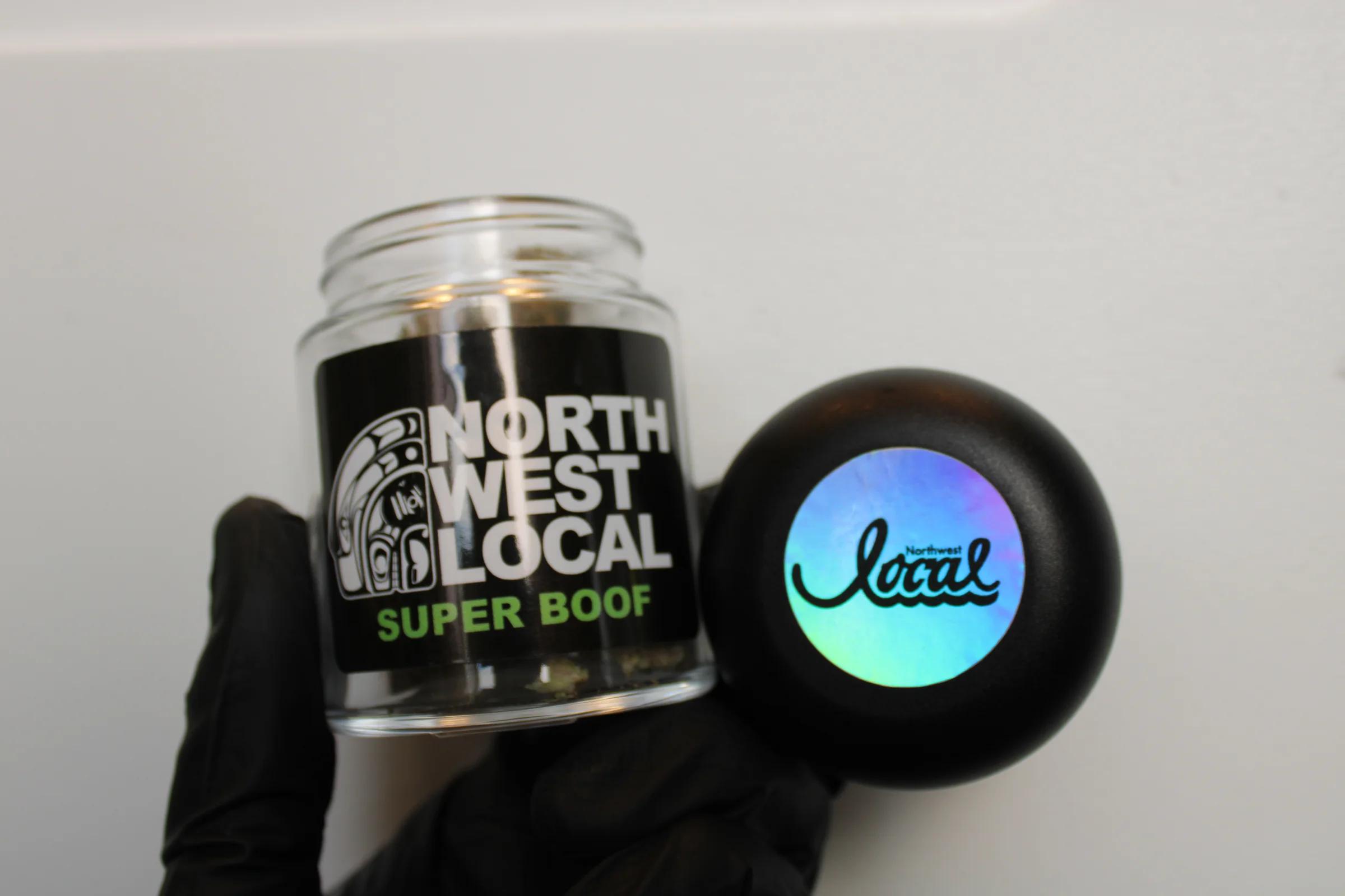 An open Super Boof jar beside its black lid, the holographic Northwest Local logo catching the light
