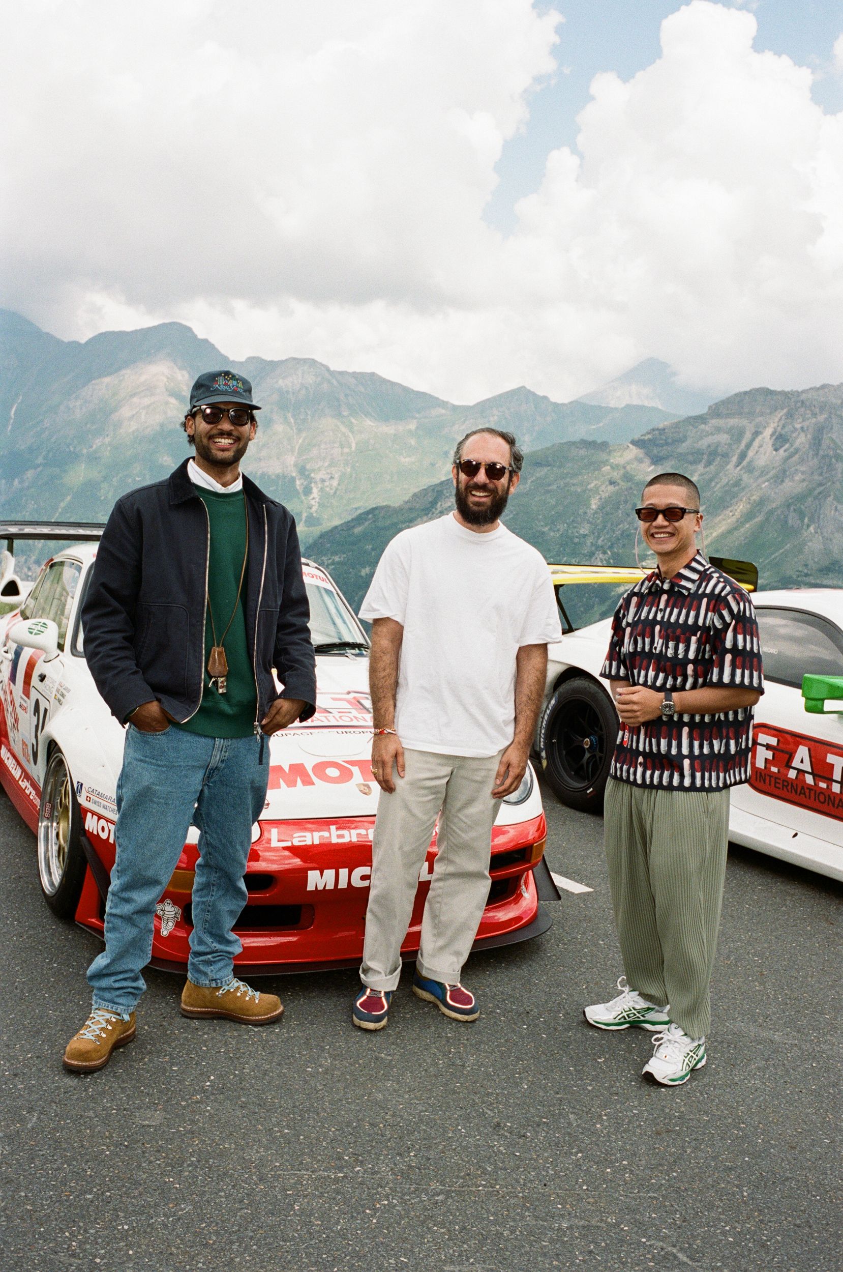 Several friends smiling, standing in front of race cars at FAT Mankei, pictured in the middle is FAT's head of marketing Yashar