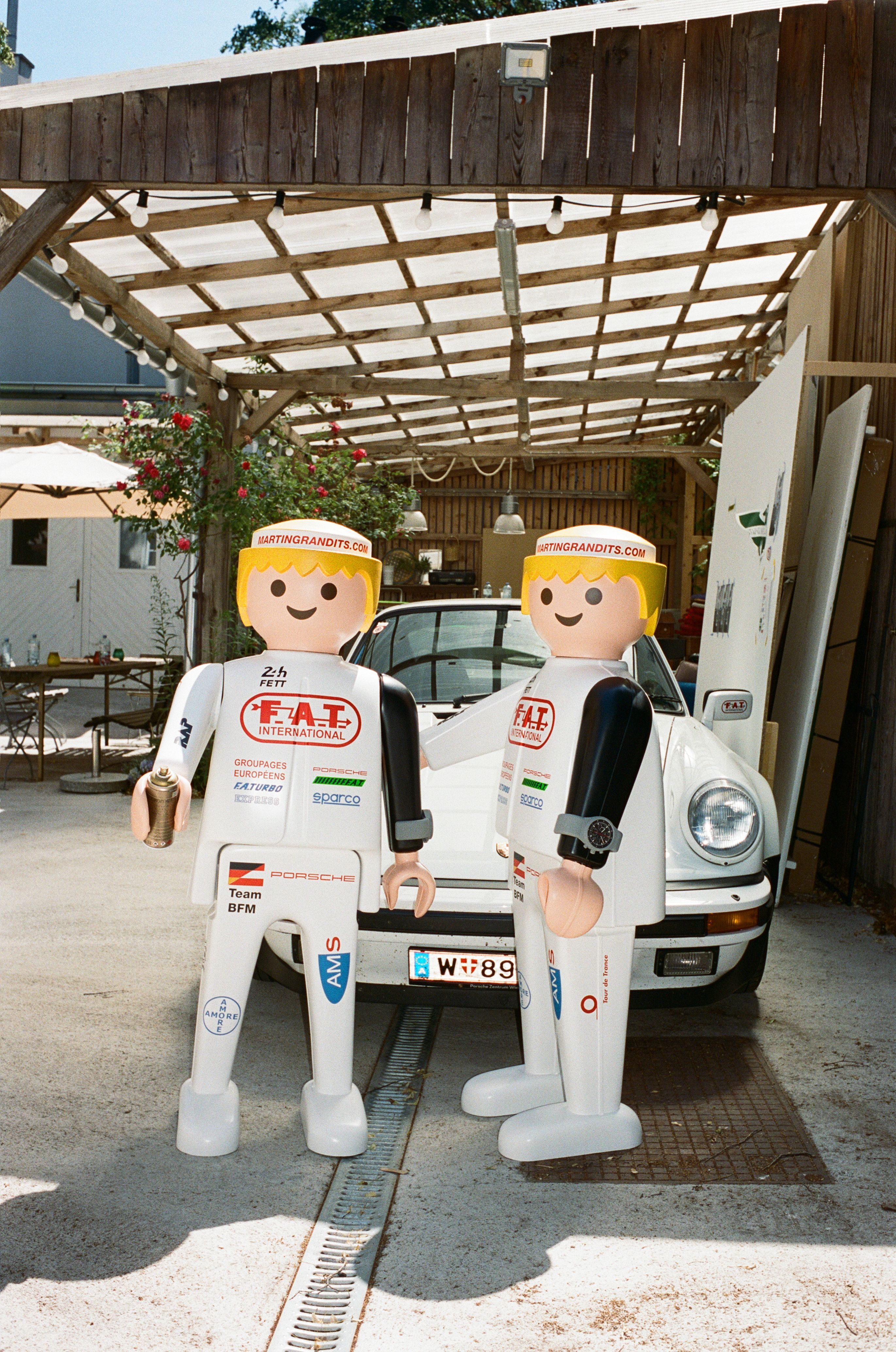 Our Playmobil FAT International duo in front of a Porsche 911 wearing full FAT International racing outfits and our Chronograph 1 watches produced in collaboration with Porsche Design