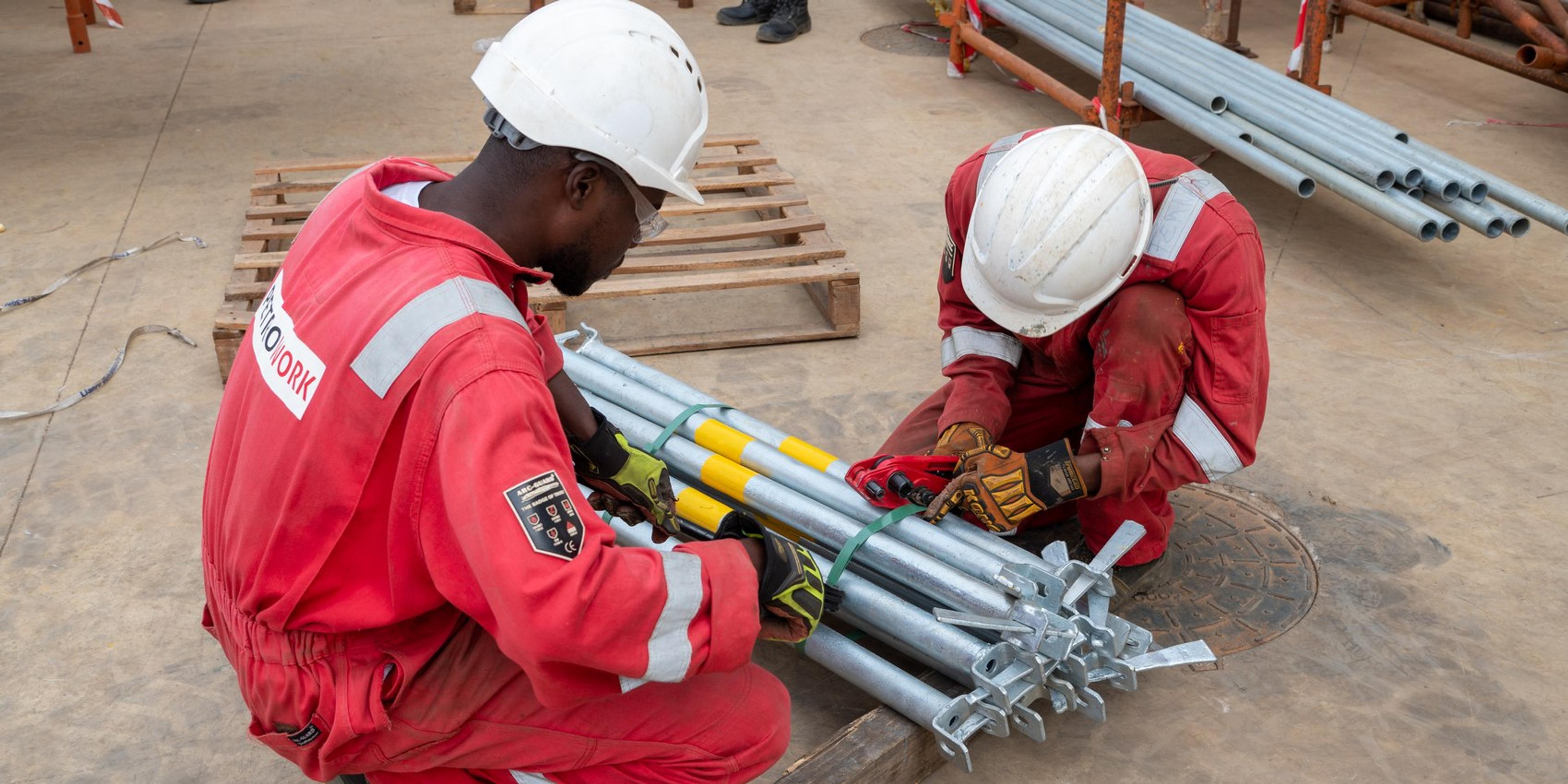 Two technicians assembling scaffolding components