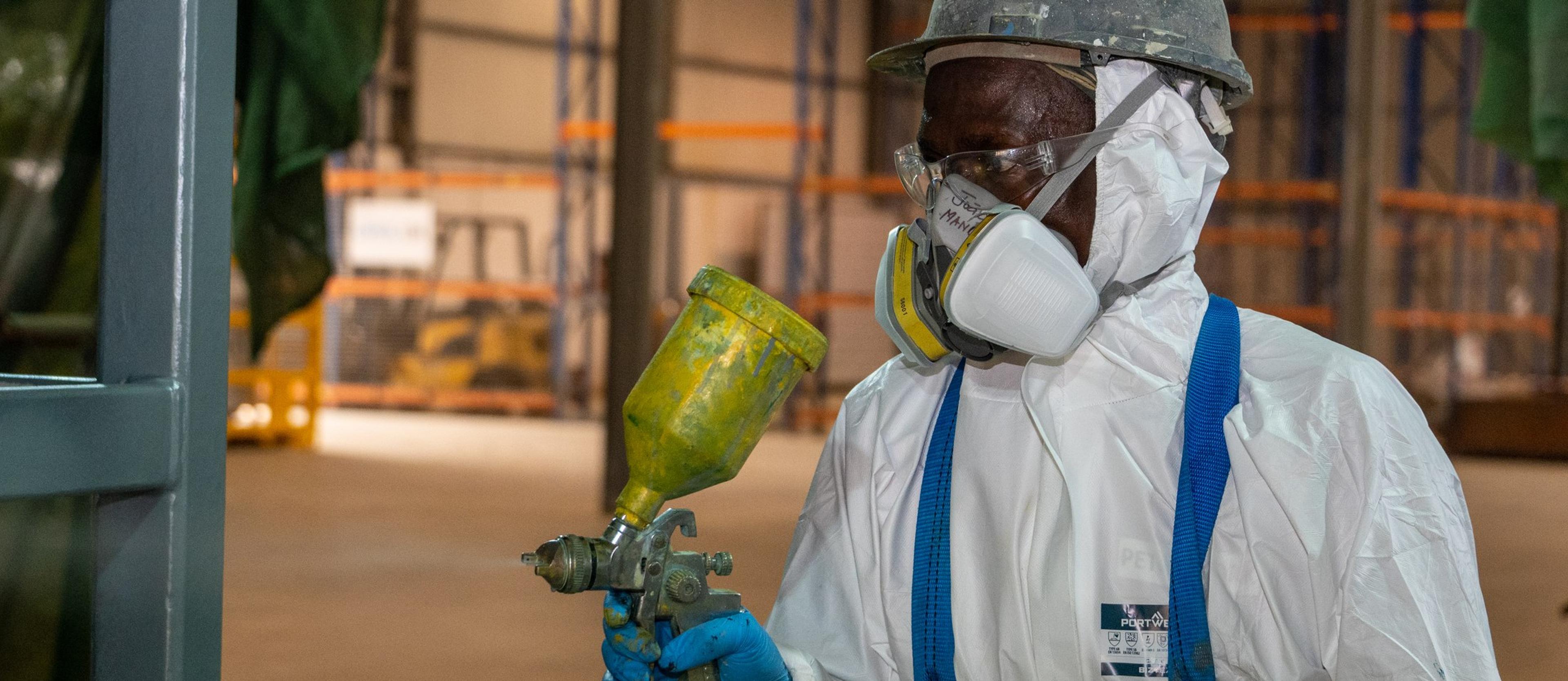 Technician spray-applying a protective coating in the Viana workshop