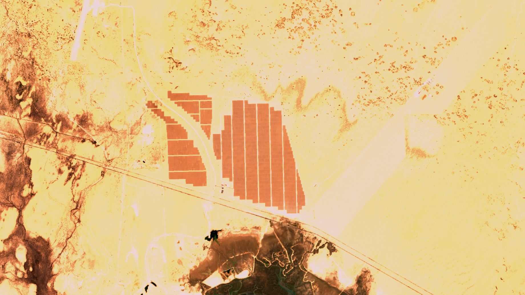 Imagen satelital de los campos de paneles solares de la central de Puerto Peñasco en el desierto de Sonora, junto a una carretera y un estero
