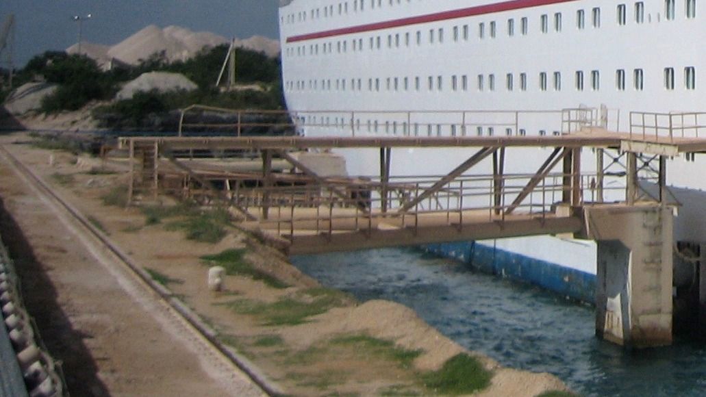 Terminal de Calica en Punta Venado, con montículos de piedra caliza, banda transportadora y muelle junto al mar