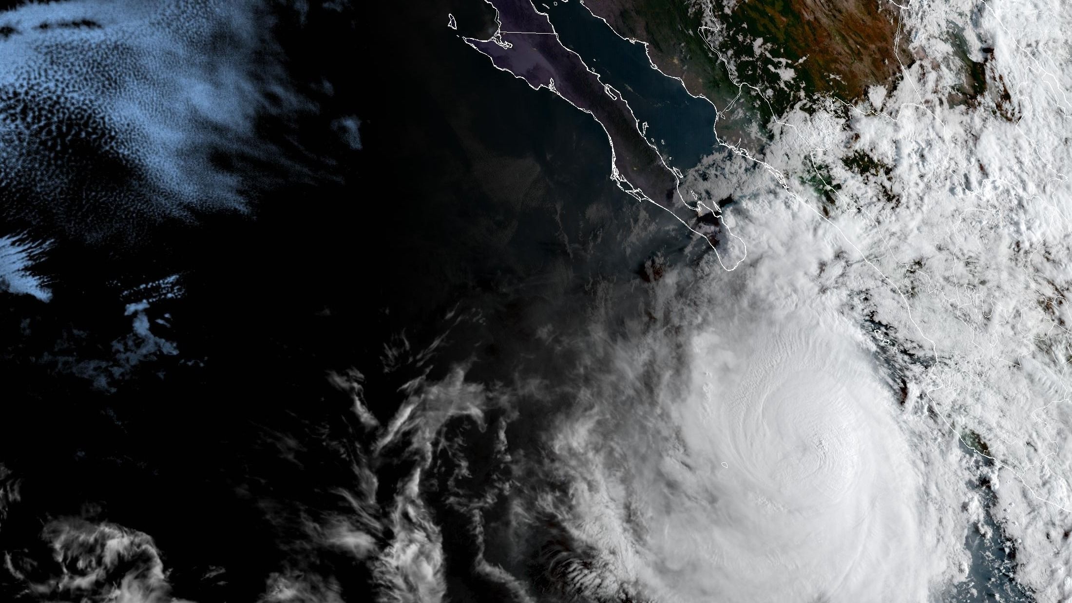 Imagen satelital en color del huracán Rachel: una espiral de nubes blancas sobre el océano Pacífico, al sur del extremo de la península de Baja California, con la costa de México delineada