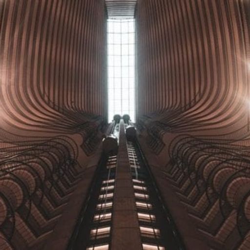 looking up at an escalator in a large building .